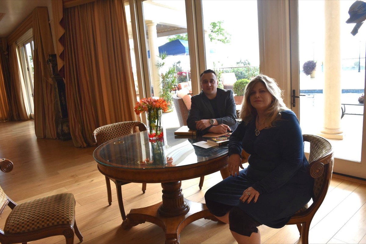 Michael Darius Eastwood in a working meeting at a table with Vicky Hamilton, former manager of Guns N Roses, books and papers on the table